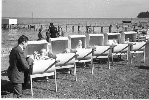 små børn sover i barnevogne på stranden