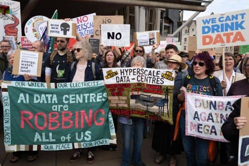 Demonstranter foran det skotske parlament protesterer mod nye AI-datacentre med skilte om miljø, strømforbrug og vandressourcer.