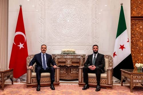 Tyrkiets udenrigsminister Hakan Fidan (tv.) bliver modtaget af lederen af Hayat Tahrir al‑Sham (HTS), Ahmed al‑Sharaa, i Damaskus. 22. december 2024.