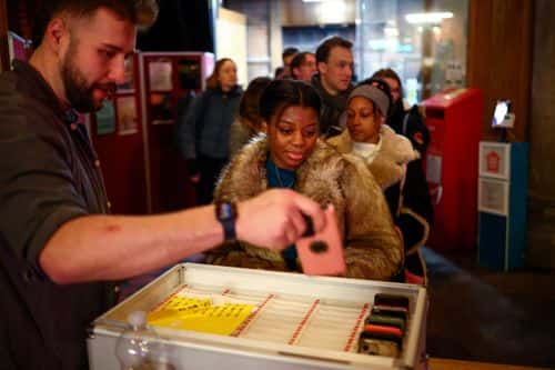 Deltagere afleverer deres mobiltelefoner ved en “digital detox”-aften arrangeret af The Offline Club i London. Februar 2025.
