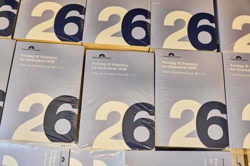 Eksemplarer af finanslovsforslaget for 2026 liggende på et bord.