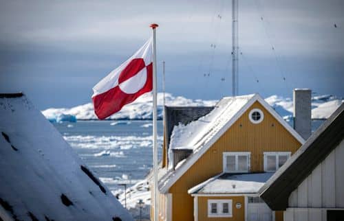 Huse i Nuuk med det grønlandske flag i centrum.