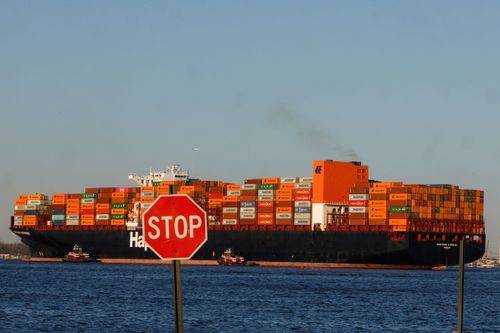 Fragtskib lastet med containere udenfor Port of Elisabeth, Bayonne, New Jersey.