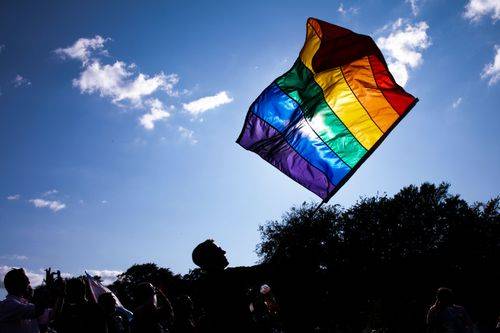 Mand går med regnbueflag under World Pride i København, august 2021
