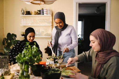 Tre muslimske kvinder laver slat i et køkken