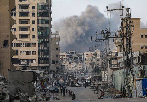 Røg stiger op, mens palæstinensere flygter fra et område ramt af et israelsk luftangreb i Gaza City den 22. september 2025.