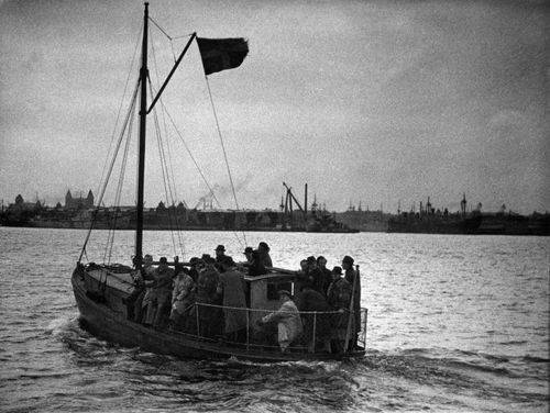 En båd med mennesker sejles over vandet om natten