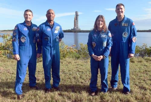 De fire astronauter, som skal i kredsløb om Månen med Artemis 2, som forventes opsendt i starten af februar 2026. I baggrunden ses Artemis 2-raketten.