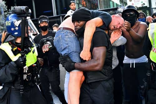 Patrick Hutchinson hjælper en såret moddemonstrant i sikkerhed under en Black Lives Matter‑demonstration i London den 13. juni 2020 efter George Floyds død.