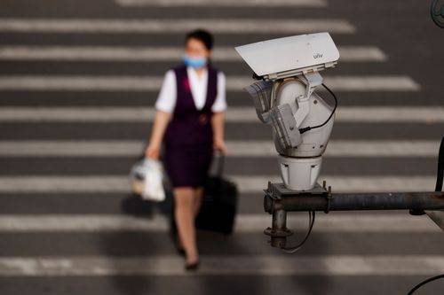 Et overvågningskamera har udsyn over en gade, mens en kvinde går forbi, efter spredningen af den nye coronavirus (COVID-19) i Beijing.