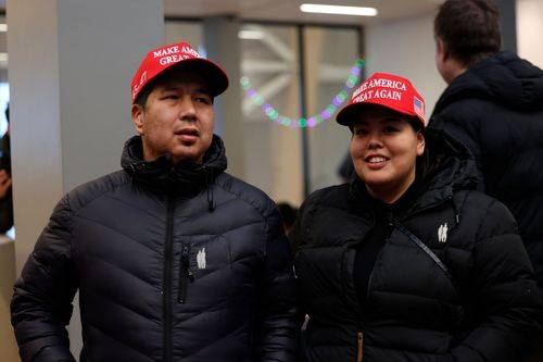 To indbyggere i Nuuk med Make America great again-kasketter