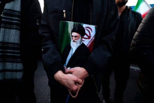 En mand holder et billede af Irans leder, ayatollah Ali Khamenei, under en sørgemarch i Teheran den 1. marts 2026. Khamenei blev dræbt i et fælles amerikansk-israelsk angreb dagen før.