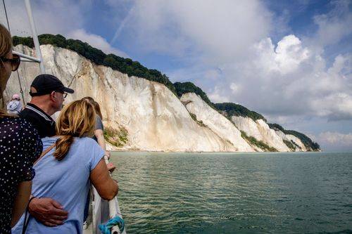 Møns Klint set fra søsiden med turister i forgrunden.