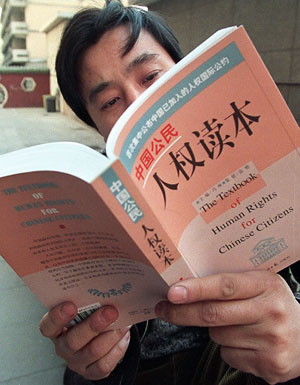En mand læser den seneste udgave om menneskerettigheder i Kina udgivet af den kinesiske regering i Beijing januar 2008. Foto: AFP Photo/Gogh Chai Hin/Polfoto