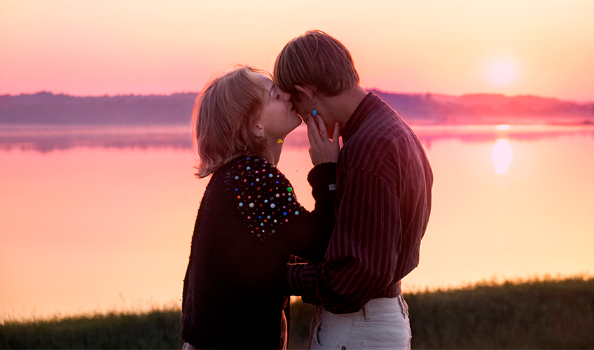 To unge kysser hinanden i solnedgangen