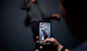 En bruger poserer til et billede, som ses igennem TikTok-appen.