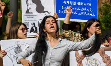 Kvinde klipper håret i protest foran den iranske ambassade i Seoul.