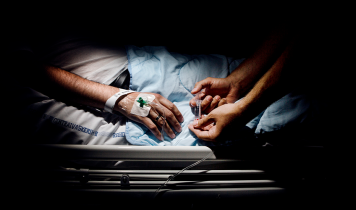 Hænder lægger drop i patient på sygehus