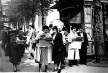 Aviserne rives væk fra kioskerne i Paris for at folk kan få de sidste nyheder om krisen med Tyskland og Hitler som førte til 2. Verdenskrig i 1939. I baggrunden Madeleine kirken.