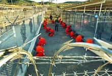Al-Qaeda og Taleban internerede i orange fangedragter under overvågning af det amerikanske militærpoliti på Naval basen i Guantanamo på Cuba. Januar 2002.
