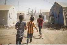 Børn fra en flygtningelejr i Kelek løber efter en madtransport.