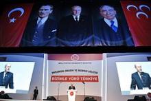Lederen af Tyrkiets nationale parti(MHP)Devlet Banceli holder en tale under billedet af det moderne Tyrkiet's grundlægger Mustafa Kemal Atatürk (tv) under valgkampen den 3. maj 2015.