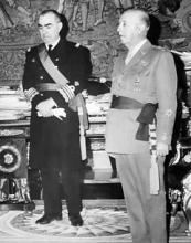 General Franco (th) har udnævnt Admiral Blanco (tv) til premiereminister den 20. juni 1973. Blanco bliver myrdet den 20. december 1973 efter et bombeangreb som ETA tager ansvaret for.
