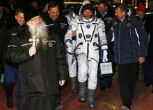 Ortodoks præst ledsager den amerikanske astronaut Scott Kelly fra NASA og de russiske astronauter Gennady Padalka og Mikhail Korniyenko fra Roscosmos på vej til ekspedition 43 i Kazakhstan den 27. marts 2015.
