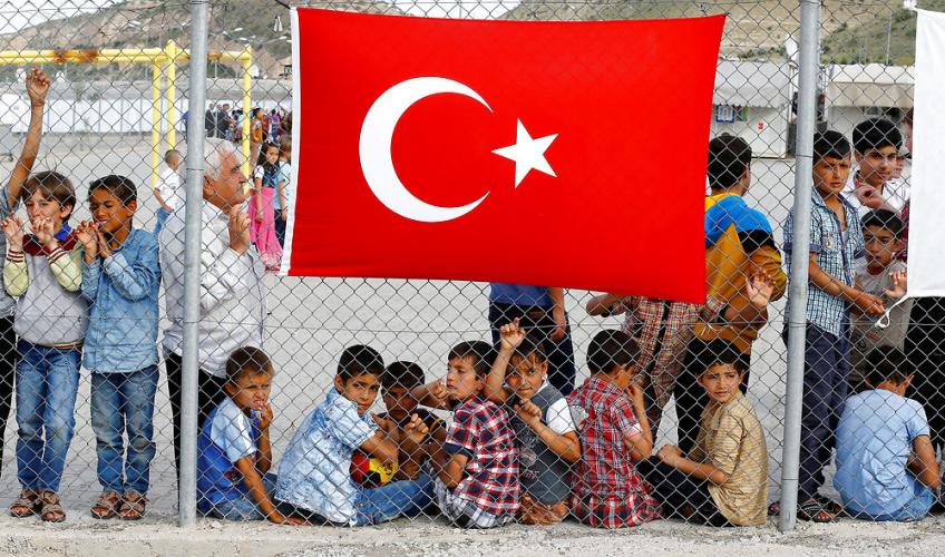 børn bag hegn med tyrkisk flag