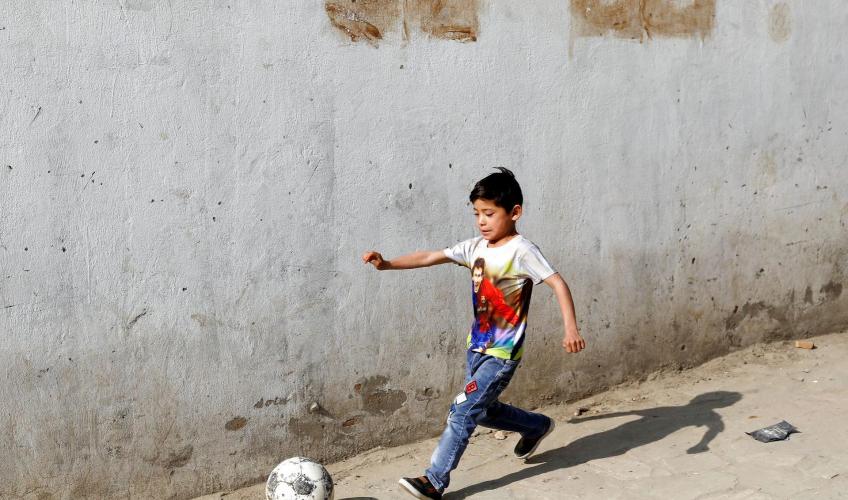Lille dreng spiller fodbold i Kabul