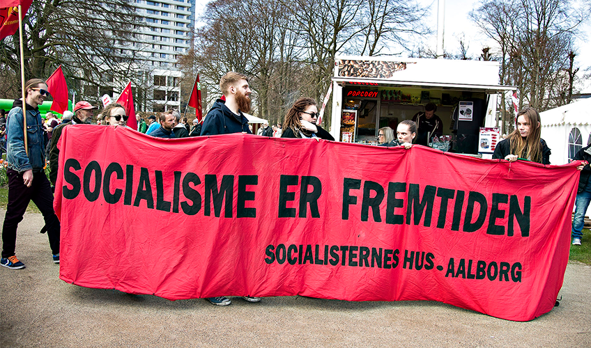 1. maj demonstration med banneret "Socialisme er fremtiden" passerer popcornbod.