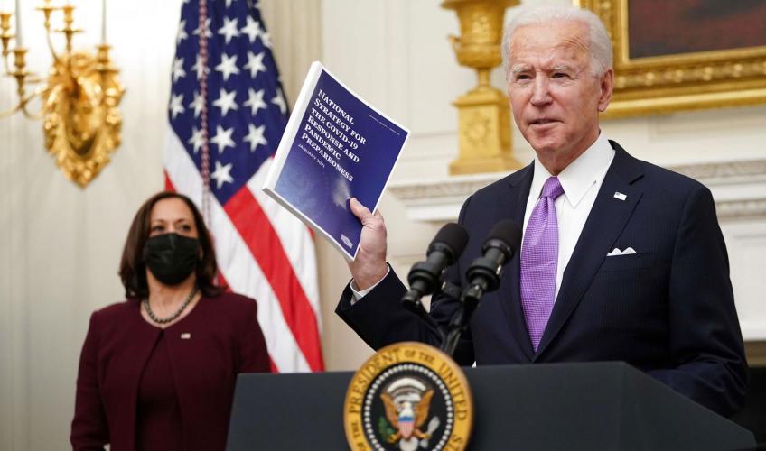 Joe Biden står på en talerstol med det amerikanske flag i baggrunden