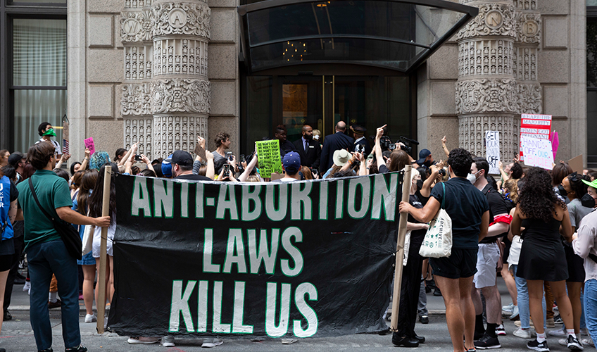 Demonstranter foran St. Patrick's Cathedral i New York holder et skilt med teksten: "Anti-abortlove slår os ihjel"