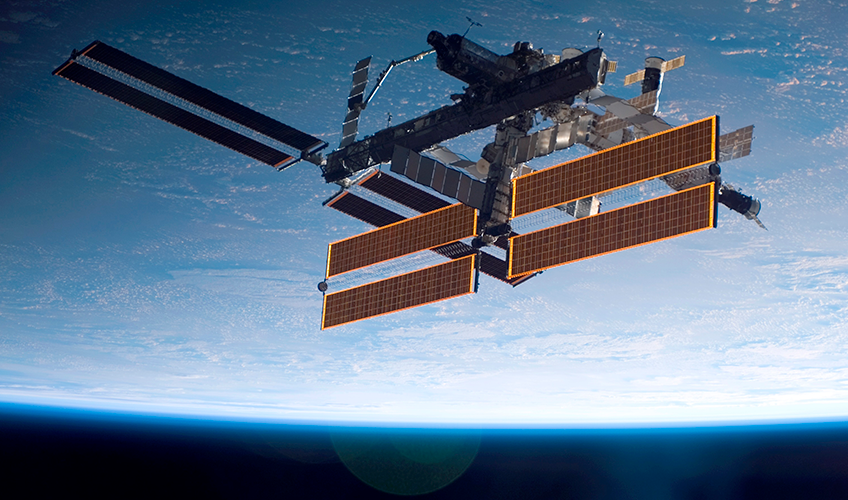 Den Internationale Rumstation med Jorden i baggrunden